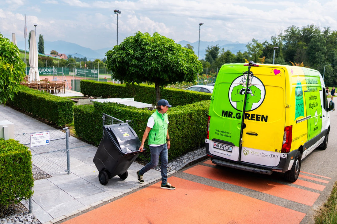 ein mann zieht einen container mit tennisbällen zum mr. green lieferwagen